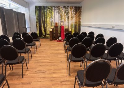 Abschiedsraum mit Bestuhlung und Waldbild-Hintergrund bei Abschied Bestattungen München Arabella